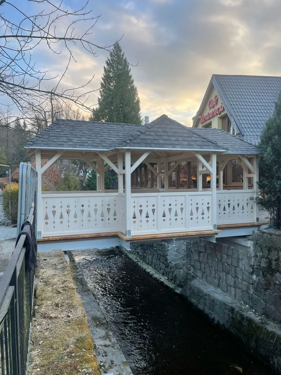 Zadaszona drewniana galeria nad kanałem wodnym przy budynku gastronomicznym