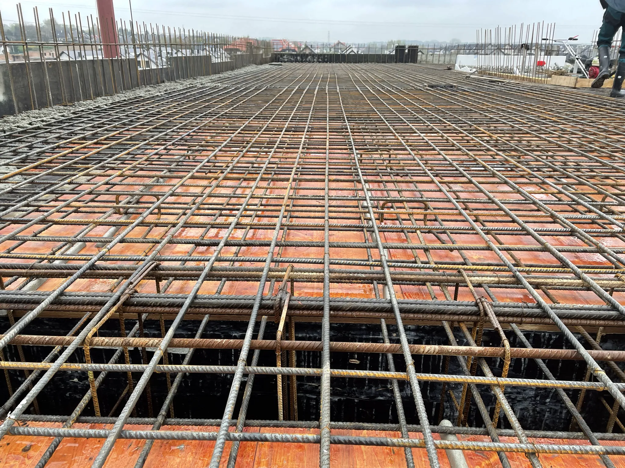 Roboty żelbetowe: zbrojenie stropu z siatki prętów stalowych na deskowaniu