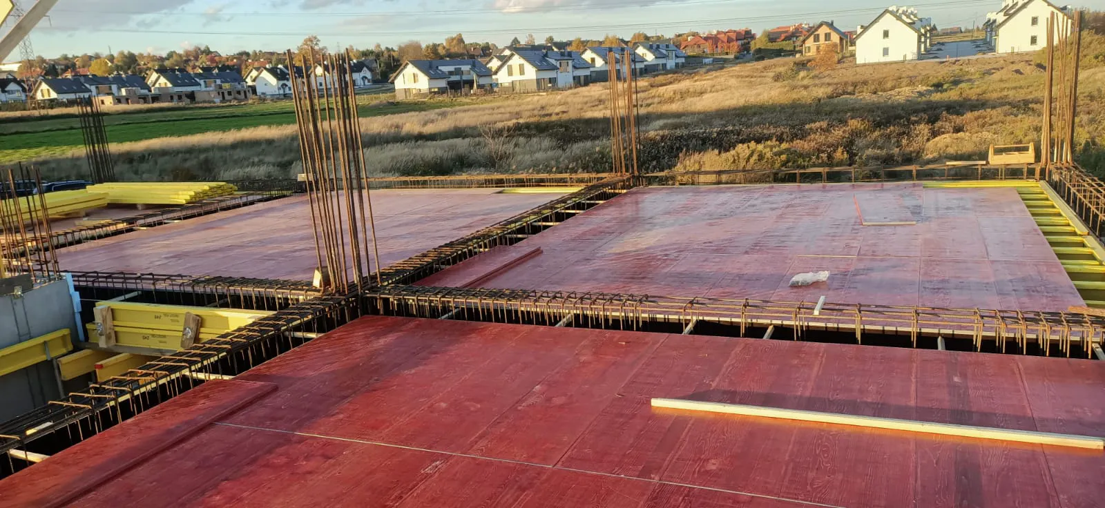 Czerwone szalunki płytowe z zbrojeniem przygotowujące strop żelbetowy – Stropy