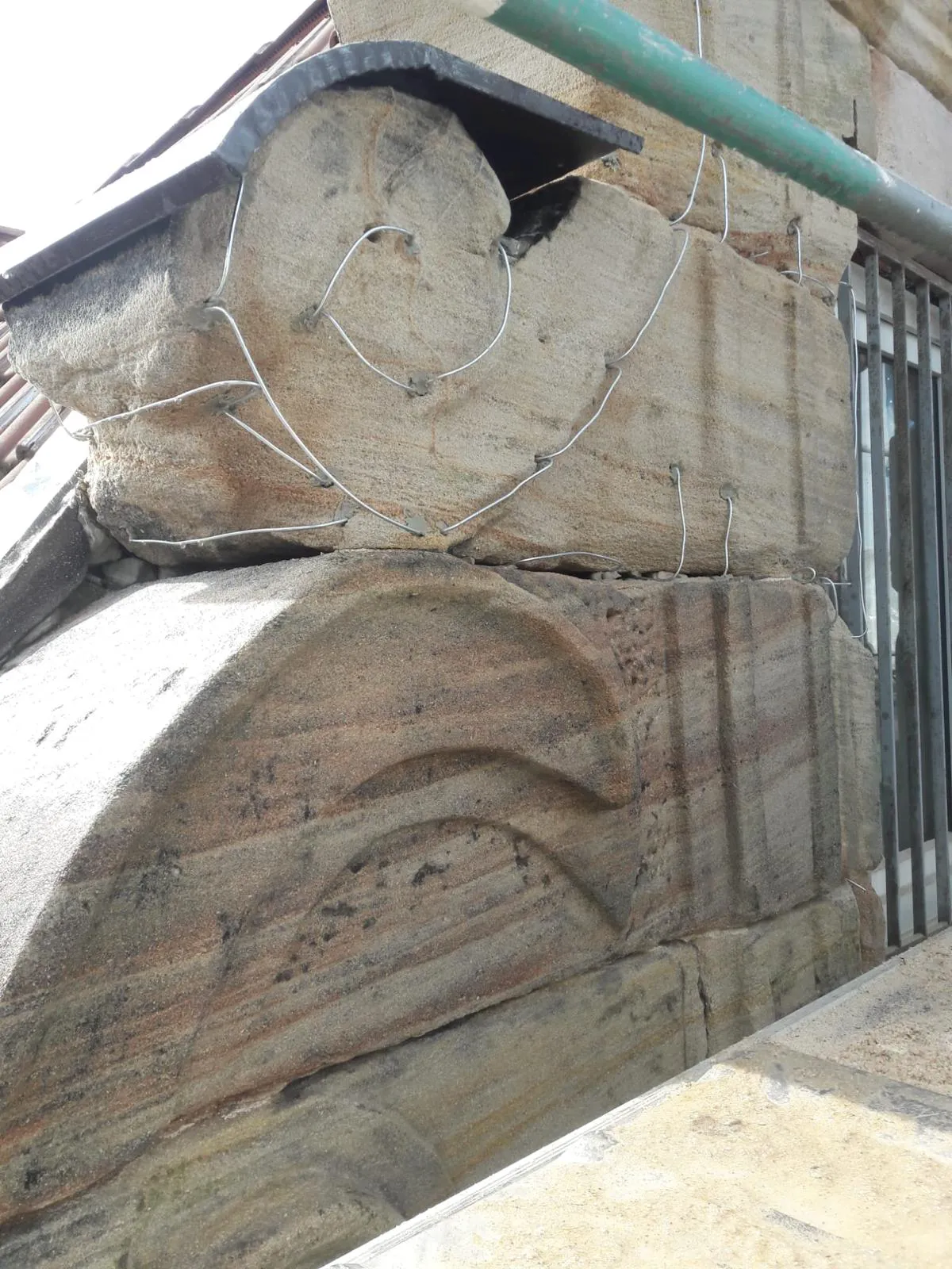 Fragment ściany z masywnych kamiennych bloków warstwowych przy oknie – Usługi kamieniarskie