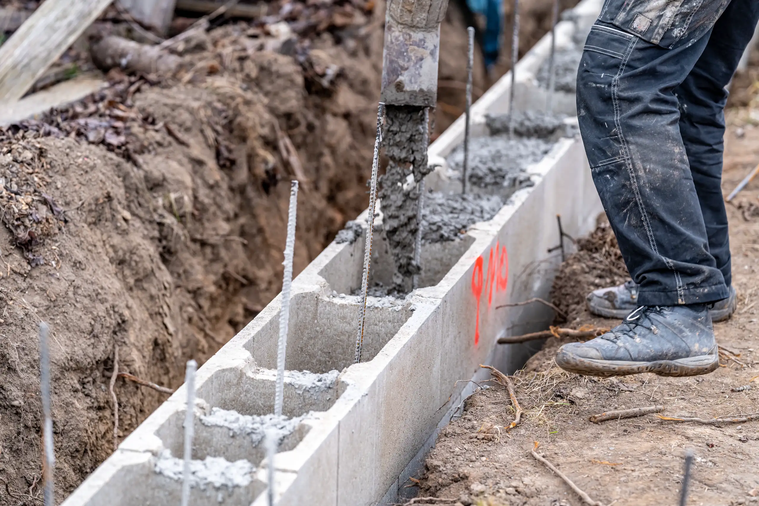 Wylewanie betonu w ławę fundamentową z bloczków i zbrojeniem