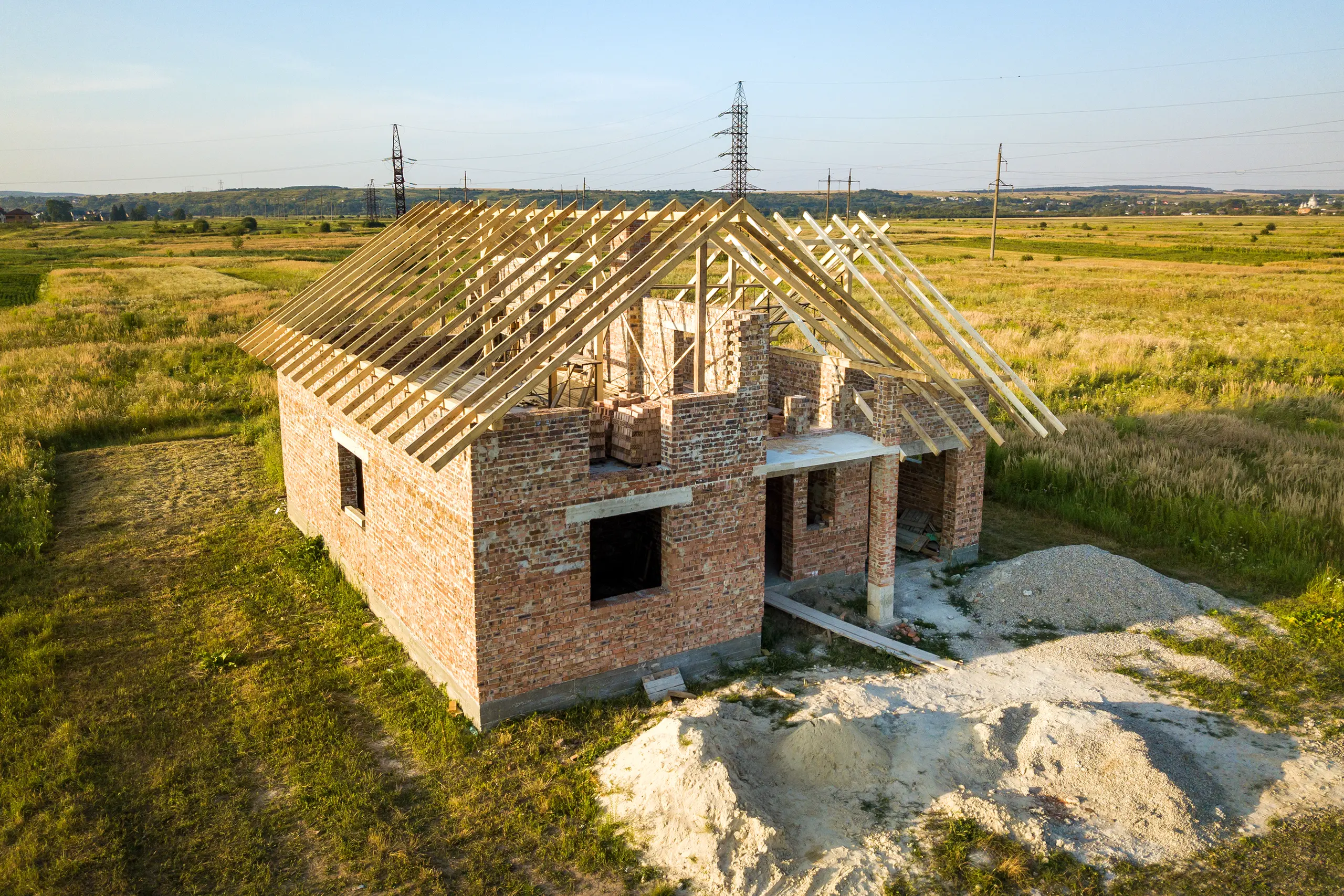 Stan surowy otwarty: dom z murowanymi ścianami i drewnianą konstrukcją dachu